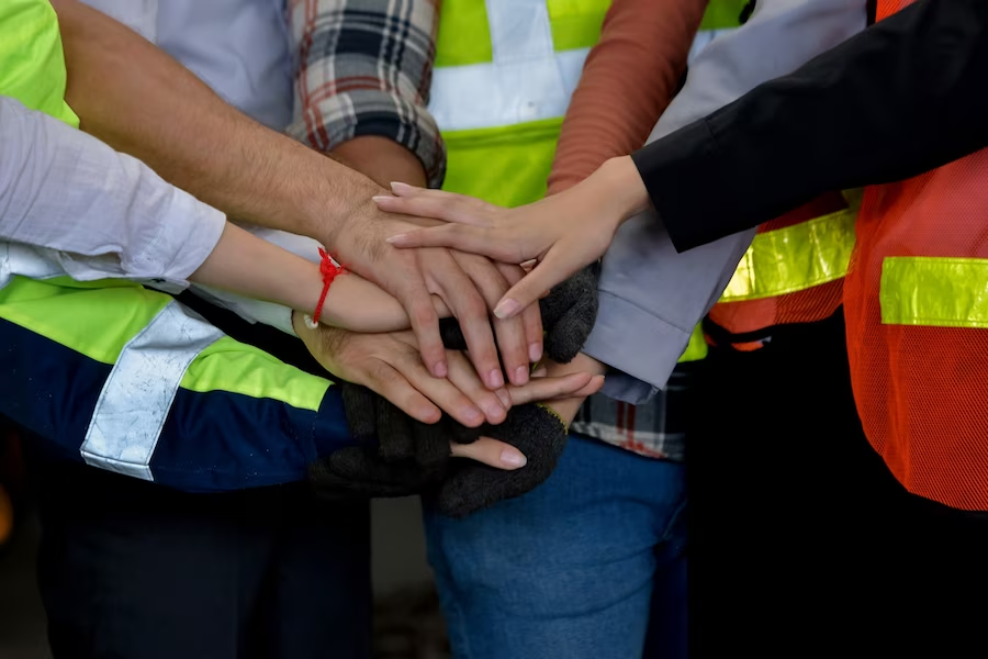 A team of people joining their hands together in unity